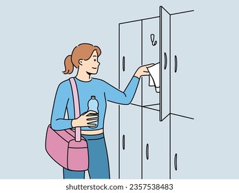 Woman visitor to gym stands near lockers for personal belongings and prepares for sports workout. Girl with bag for sportswear and bottle of water visits gym to maintain good figure