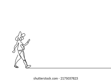 a woman is walking by reading a book in her hand