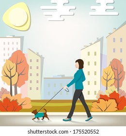 The woman walks with a dog in the fall