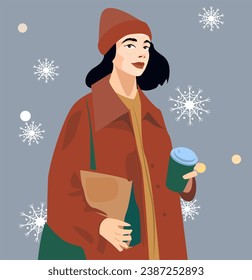 A woman in a warm coat and hat holds a mug of coffee in her hands. A winter walk through the falling snow. in the girl’s hands there is a package with food or gifts for Christmas, New Year 