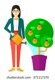 Woman watering tree with light bulbs.