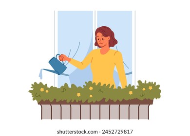 Woman waters flowers, standing on balcony near window to decorate facade of building with greenery and flowers. Girl takes care of plants from balcony, being interested in gardening and botany.