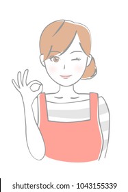 A woman wearing an apron shows an okay sign