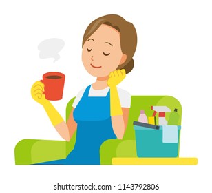 A woman wearing a blue apron and rubber gloves sits on the sofa and is drinking coffee