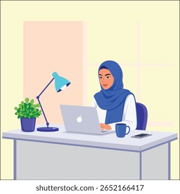  woman wearing a blue hijab is working on her laptop at a desk. there is a lamp, plant, and coffee mug on the desk. the scene is bright and modern looking.