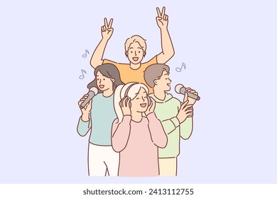 Woman wearing headphones listens to popular music, standing near singing people with microphone. Girl dressed in casual style enjoys cool sound of music and pop songs in wireless earphones