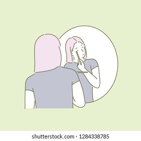 A woman is wearing makeup in a mirror. hand drawn style vector design illustrations.