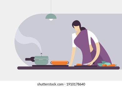 A woman wearing 'Sari'cutting vegetables and cooking in a kitchen