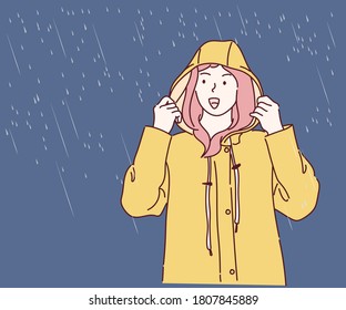 Woman wearing yellow raincoat out in the rain. Hand drawn in thin line style, vector illustrations.