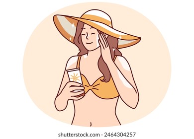 Eine Frau, die sich sonnen möchte, trägt Sonnenschutzcreme auf die Haut auf, um sich vor Sonnenstich zu schützen oder übermäßige Bräune zu vermeiden. Mädchen in Bikini und Strandhut mit Sonnencreme genießen Sommerurlaub