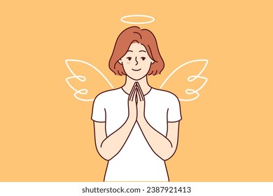 Woman with wings and angel halo stands making prayer gesture, calling on people to be kinder and more tolerant. Girl dressed as angel advertises charity fund supporting those in need.