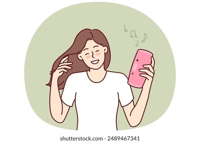 Woman with wireless portable speaker smiling enjoying loud rhythmic music of favorite rock band. Young girl with pink portable speaker enjoys listening to playlist, creating disco atmosphere