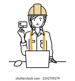 a woman working at construction sites using laptop computer at her desk and holding a credit card