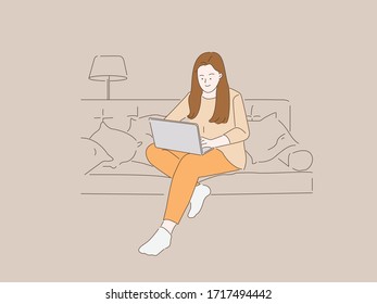 Woman working from home on a laptop sitting comfortably on the couch.