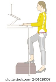 A woman working on a computer at a standing desk