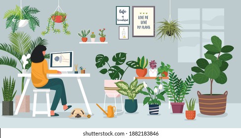 Woman working on laptop at home decorated with indoor plants
