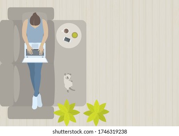 Woman working on laptop and laying down on sofa in living room with cat, table, smart phone, coffee, carpet, plant and wood floor from top view