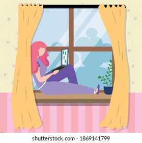 A woman works at a laptop while sitting on the windowsill at home. Freelance concept, quarantine due to covid-19.
