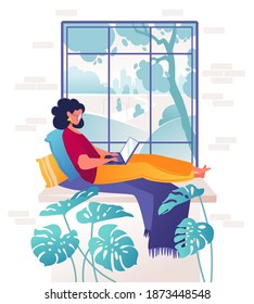 Woman works remotely, lying on comfortable windowsill creative designer or manager chatting with colleagues on laptop, landscape visible outside window. Cozy interior, advantages of self-employment. 