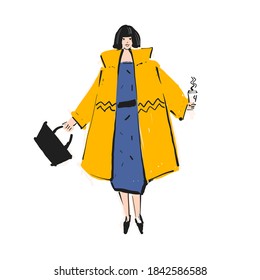 Woman in a yellow coat with black bob and black bag. Autumn and winter look.