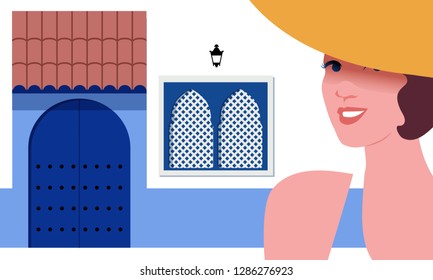 Woman with yellow hat, on background of typical Mediterranean village Moorish style. Blue door under a roof, bluish zocalo and Moorish windows.