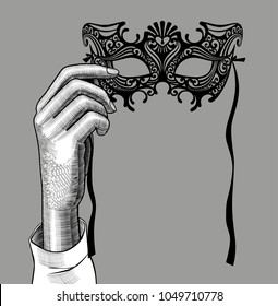 Woman's hand with a decorative carnival Venetian mask. Vintage stylized drawing. Vector illustration