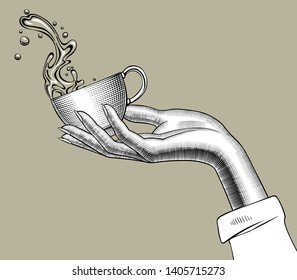 Woman's hand holding a Coffee cup with a splashed water. Vintage stylized drawing. Vector illustration