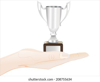 Woman's hand holding object- Silver trophy cup on white background. 