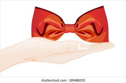 Woman's hand holding object-red ribbon bow
