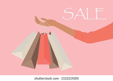A woman's hand holding shopping bags.Hand with multicolored shopping bags. Big sale concept vector Illustration.