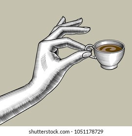 Woman's hand with a small coffee cup. Vintage stylized drawing. Vector illustration