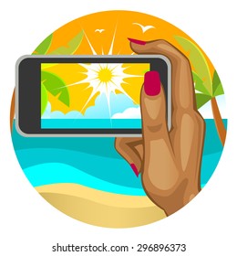 Woman's hand with the smart phone in the background of the beach
