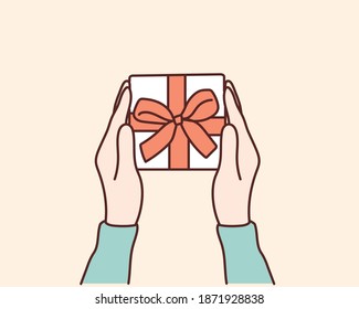 Womans hands holding gift or present box decorated confetti on yellow pastel table top view.Hand drawn style vector design illustrations.