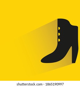women boot with shadow on yellow background