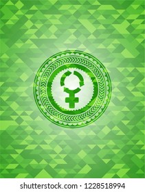 women cycle icon inside green emblem with triangle mosaic background