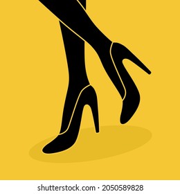 Women legs with high heels on yellow background.