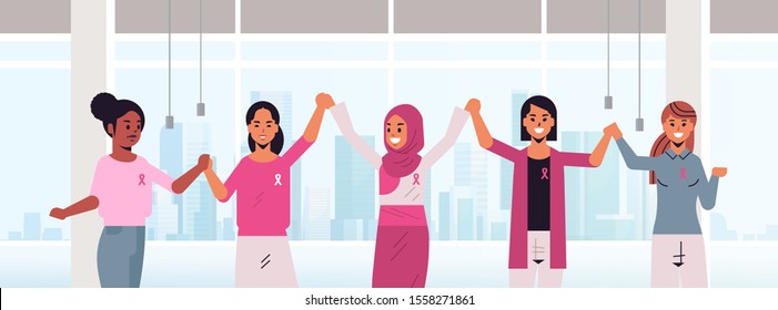 women with pink ribbons holding hands mix race girls standing together breast cancer day disease awareness and prevention concept modern office interior flat portrait horizontal vector illustration