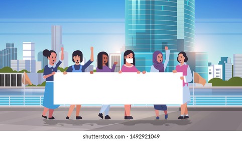 women protesters holding blank placard mix race girls activists with empty sign banner protest demonstration strike concept modern cityscape skyline background flat full length horizontal