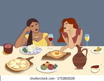 Women at the table eating traditional Georgian Food: khachapuri, khinkali and drinking red and white wine. Concept for traditional Georgian cuisine restaurants and tourism.