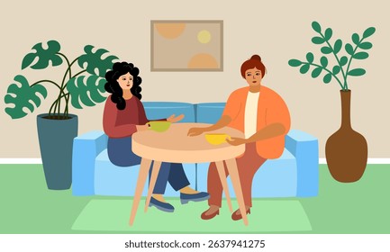 Womens gathering in a cafe or at a party. Two girlfriends are sitting at a table on a blue sofa. They are drinking tea. In the background there is a vase or a pot 