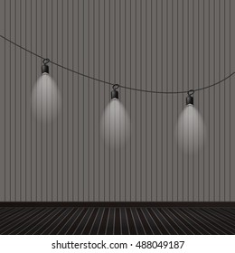 Wood floor and wall background with 3 black lamp hanging on a rope.