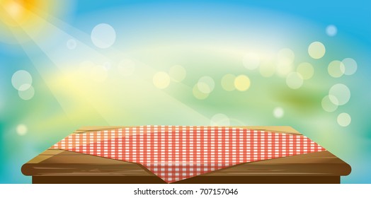 Wood table top with tablecloths on green and blue blurred abstract background.