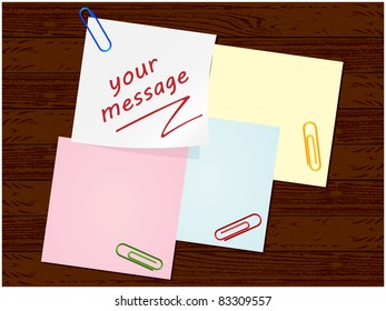 Wooden background with paper for notes and leafs clips