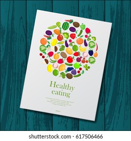 Wooden background with white brochure with fruit and vegetables