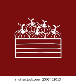 A wooden box filled with several pumpkins against a red background