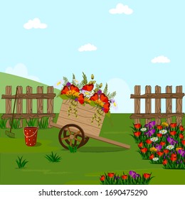 Wooden cart with flowers in the flowerbed