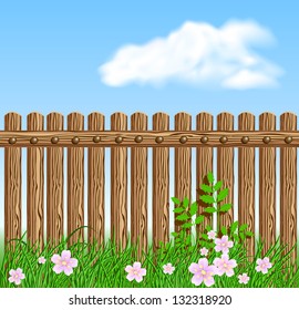 Wooden fence on green grass with flowers against the sky