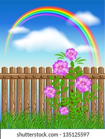 Wooden fence on green grass with flowers against the sky