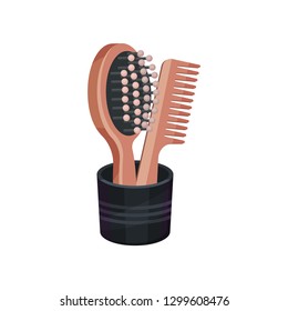Wooden hairbrush and comb in black cup. Hairdressing symbols. Beauty industry. Flat vector icon