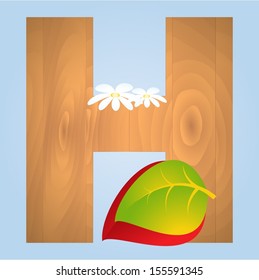 Wooden letter with autumn leaves on blue background